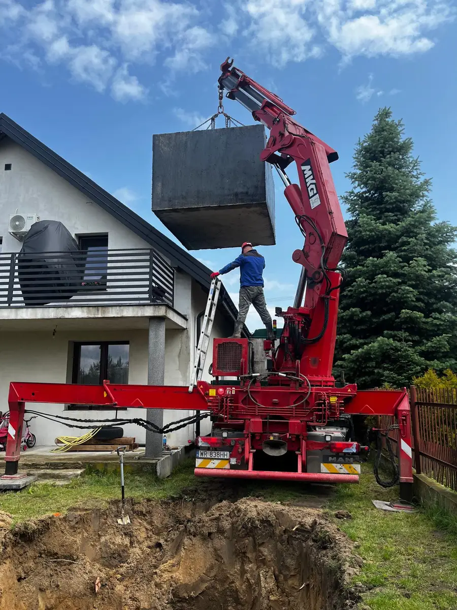 Posadowienie szamba betonowego żurawiem HDS przy domu jednorodzinnym
