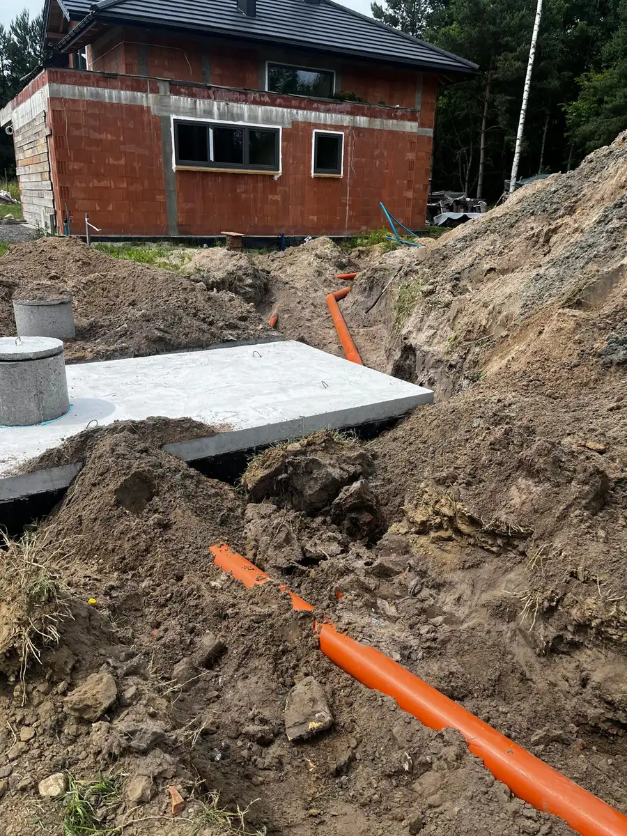 Instalacja kanalizacji szamba przy domu w budowie - rury PVC
