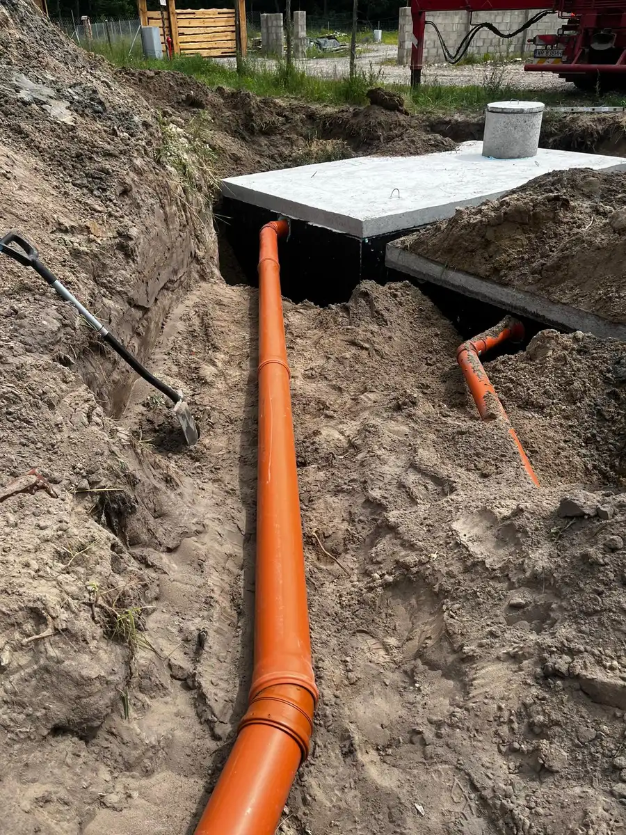 Szambo betonowe z podłączonymi rurami kanalizacyjnymi PVC