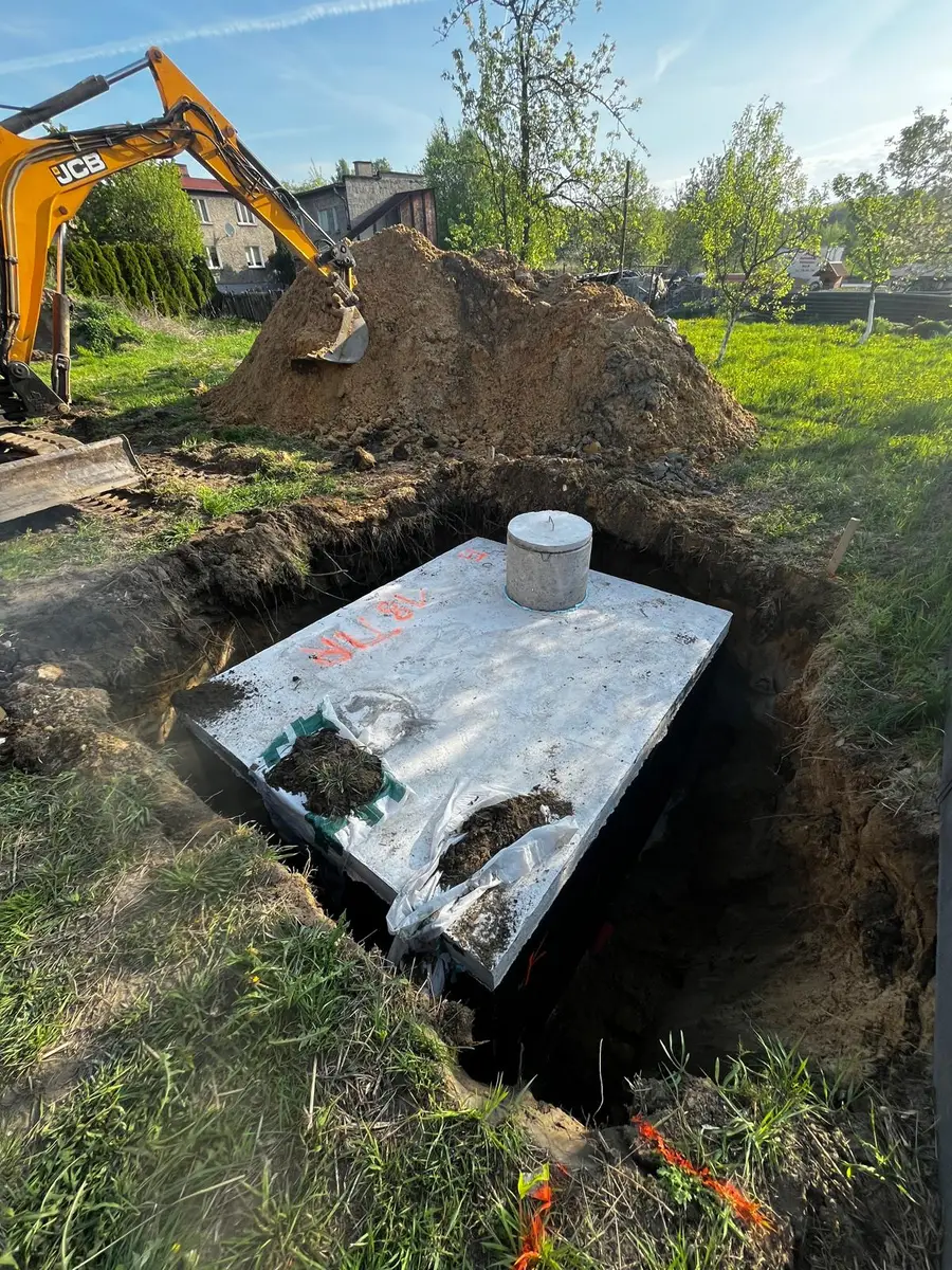 Szambo betonowe w wykopie - ogród, JCB, wiosna