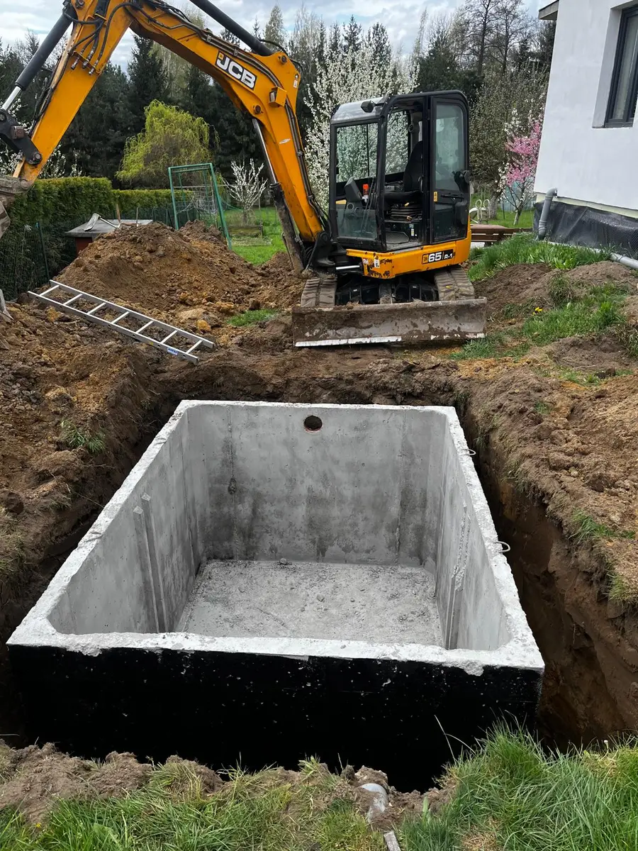 Montaż dużego zbiornika betonowego prostokątnego - koparka JCB w pracy
